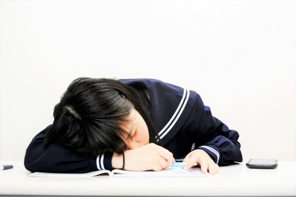 机で寝る中学生